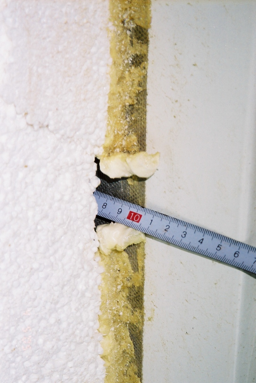 11 Zasunutí měřidla do spáry mezi pěnový polystyren a panelovou stěnu na hloubku přes 100 mm