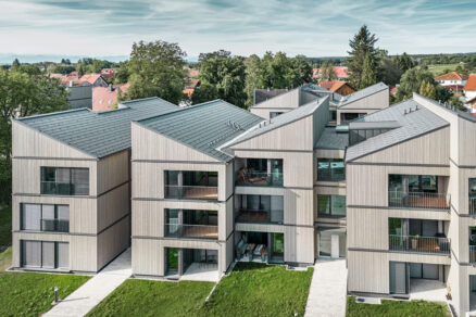 Moderní dřevostavby se sedlovými střechami obklopené zelení – projekt od studia WWA Architekten.