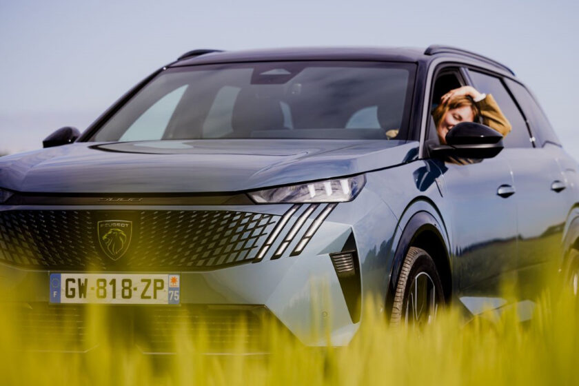 Detailní pohled na přední část SUV Peugeot 5008 s řidičkou vychutnávající si jízdu