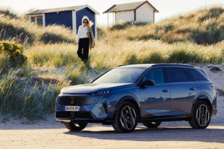 SUV Peugeot 5008 na písečné cestě s elegantní ženou v pozadí